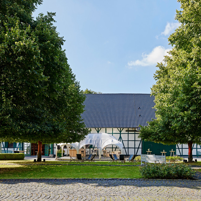 Die Hofreite im Hofgut Mappen ist umrahmt von historischen Gebäuden und ist eine grüne Oase.