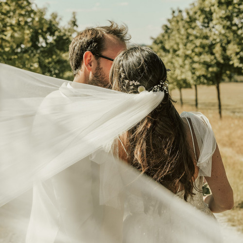 Küssendes Brautpaar während ihrer Hochzeit auf dem Hofgut Mappen.